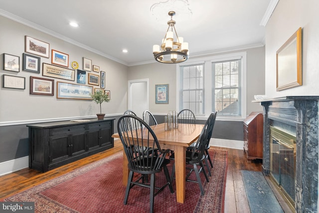 dining space featuring a premium fireplace, dark wood-style floors, and ornamental molding