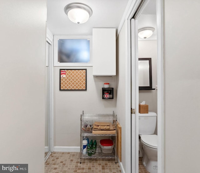 bathroom with toilet and baseboards