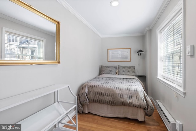 bedroom featuring a baseboard radiator, wood finished floors, and crown molding