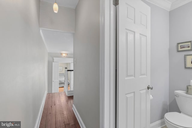 hallway featuring baseboards and dark wood finished floors