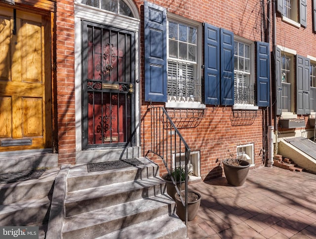 entrance to property featuring brick siding