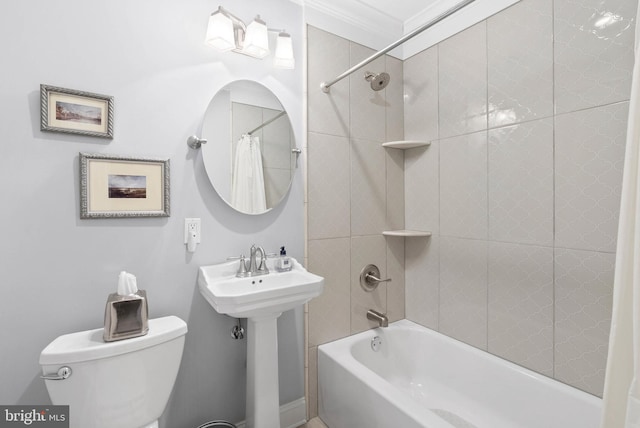 bathroom with a sink, toilet, ornamental molding, and shower / bath combination with curtain