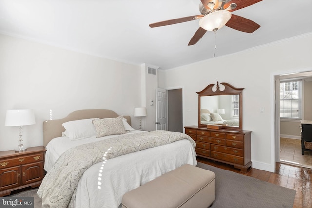 bedroom with visible vents, ceiling fan, baseboards, ornamental molding, and hardwood / wood-style floors