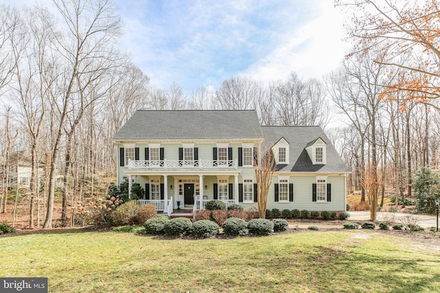 view of front of home with a balcony, covered porch, a front lawn, and roof with shingles