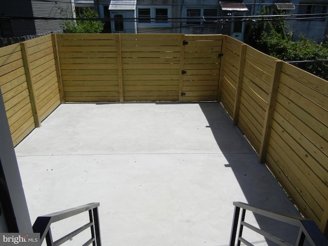 view of patio with a balcony and fence