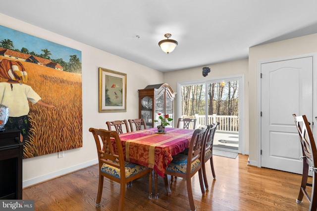 dining area with baseboards and wood finished floors