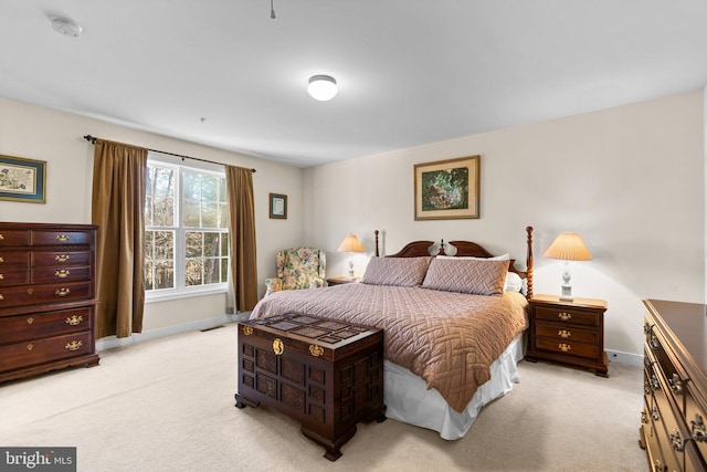 bedroom featuring visible vents, light colored carpet, and baseboards