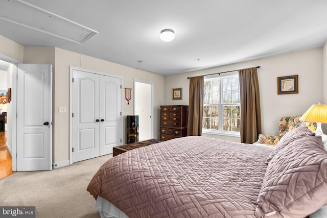 carpeted bedroom featuring attic access and a closet