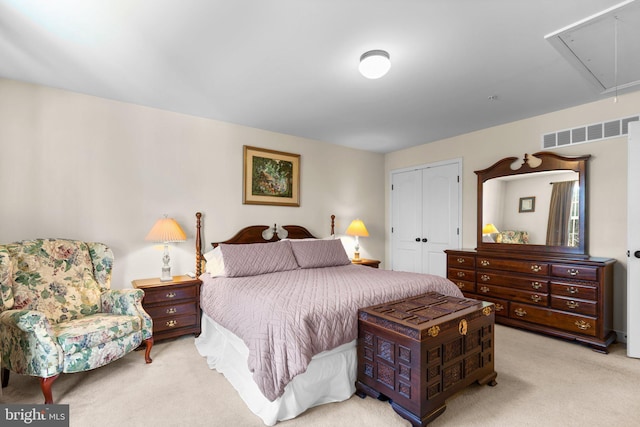 carpeted bedroom featuring visible vents, attic access, and a closet