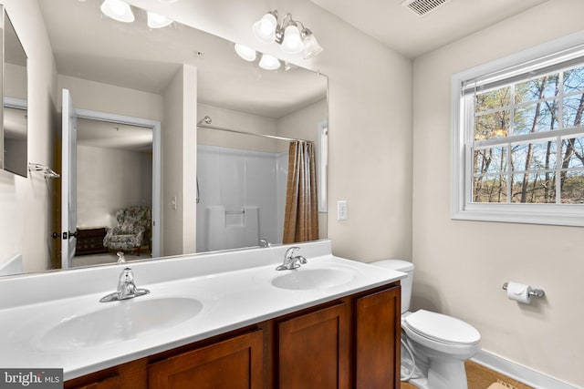 full bathroom with double vanity, toilet, visible vents, and a sink