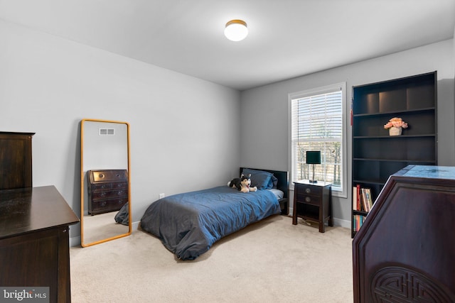 bedroom with baseboards and light carpet