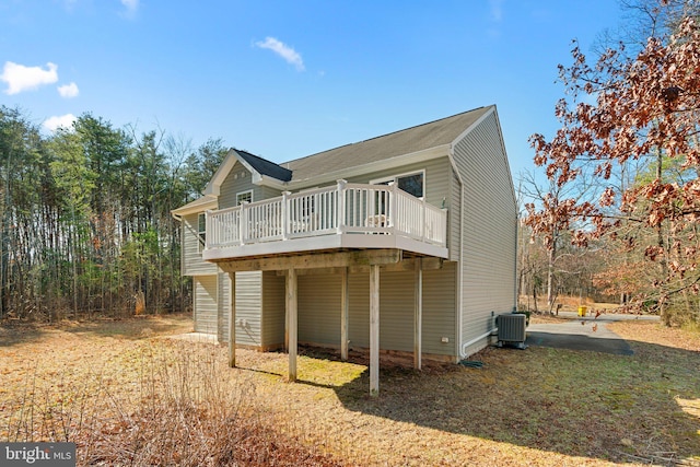 rear view of property featuring cooling unit and a wooden deck