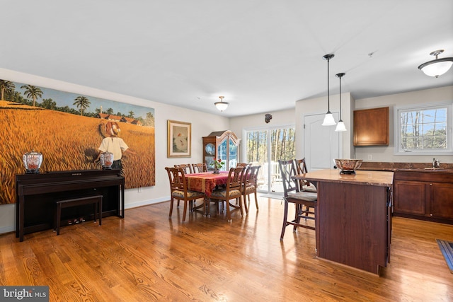 dining room with light wood-type flooring and baseboards