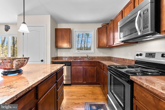 kitchen with a healthy amount of sunlight, stainless steel appliances, light wood-style floors, and a sink