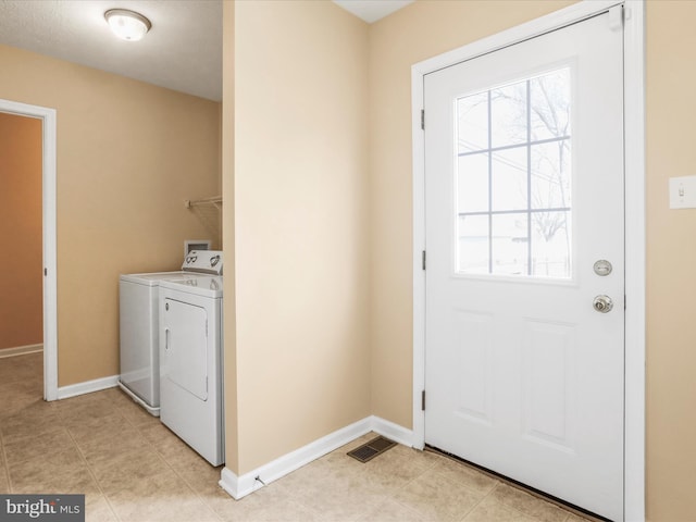 clothes washing area with washer and clothes dryer, laundry area, a healthy amount of sunlight, and visible vents