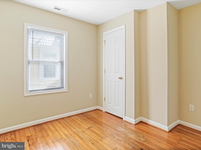 unfurnished bedroom with visible vents, light wood-type flooring, and baseboards