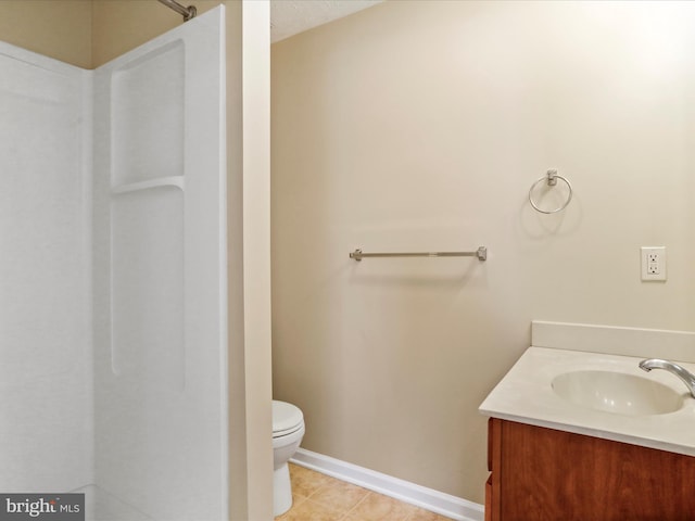 full bath featuring toilet, tile patterned flooring, baseboards, walk in shower, and vanity