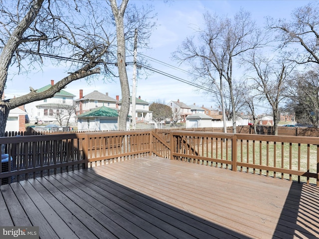 wooden terrace with a fenced backyard, a residential view, and a lawn