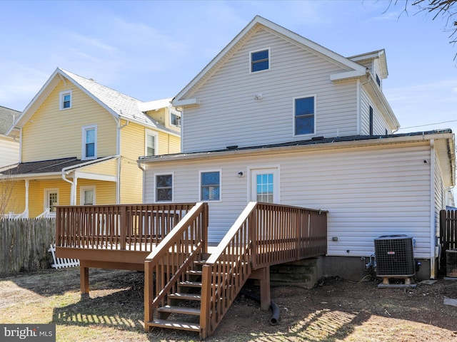 back of property with central air condition unit, a deck, and fence