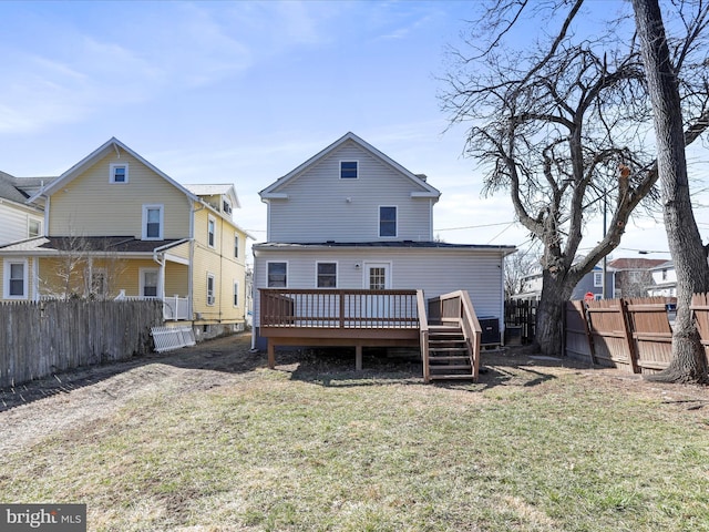 rear view of house featuring a yard, a deck, and a fenced backyard