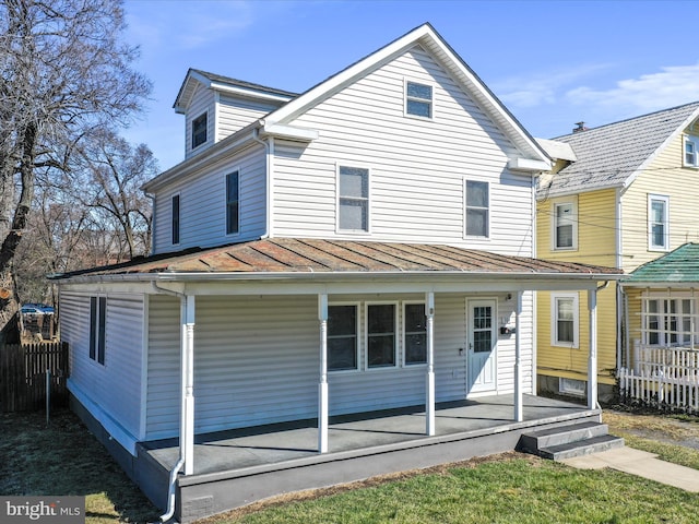 view of front of property with a standing seam roof, fence, covered porch, and metal roof