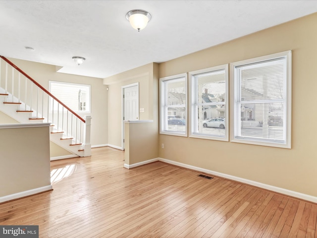 foyer featuring stairway, baseboards, visible vents, and hardwood / wood-style floors