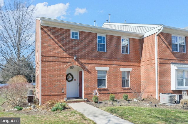 view of front of home with cooling unit and brick siding