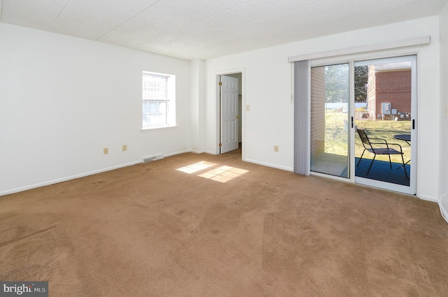 unfurnished room featuring visible vents, carpet, and baseboards