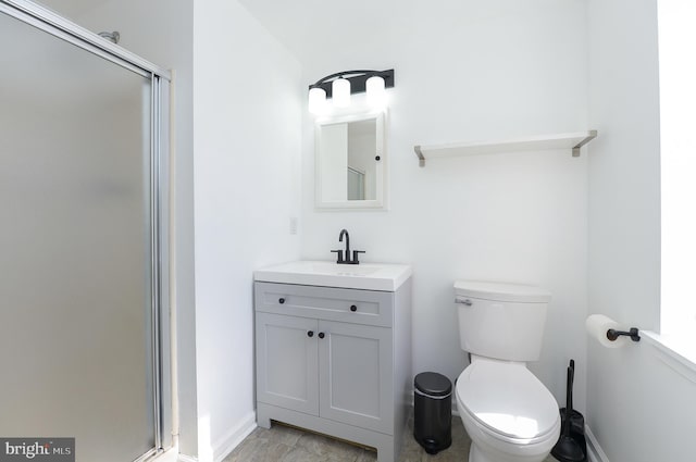 bathroom featuring a stall shower, toilet, and vanity