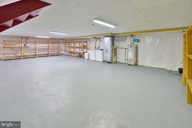 garage featuring washer and dryer, gas water heater, and heating unit