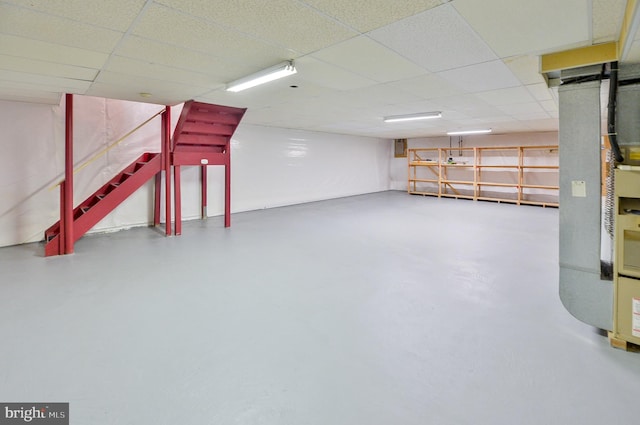 finished basement featuring stairway and a drop ceiling