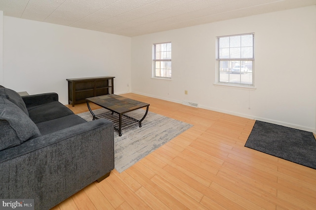 living area featuring visible vents, baseboards, and light wood-style floors