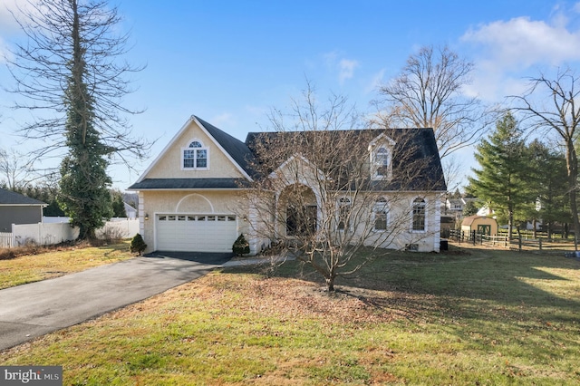 view of front of home with a front lawn, fence, a garage, and driveway