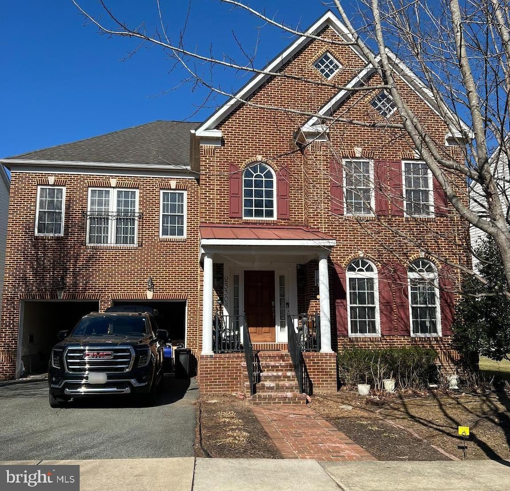 view of front facade with a garage, brick siding, driveway, and a shingled roof