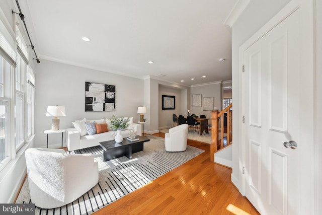 living room with wood finished floors, recessed lighting, crown molding, baseboards, and stairs