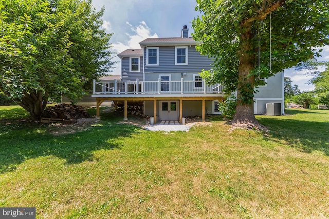 back of property with a deck, a patio, central AC, a yard, and a chimney