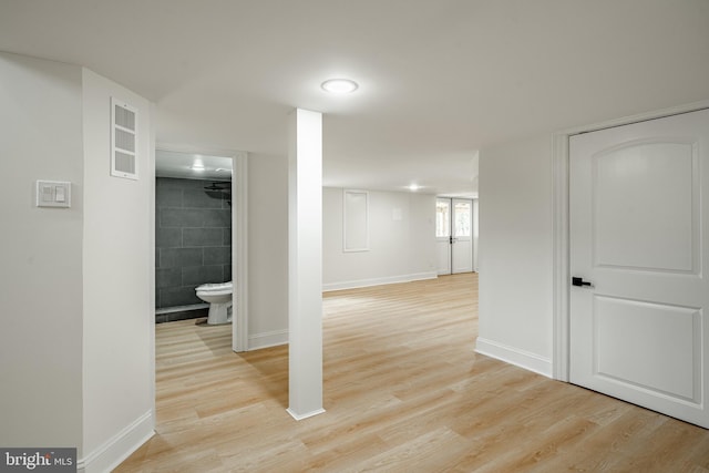 basement with light wood-type flooring and baseboards