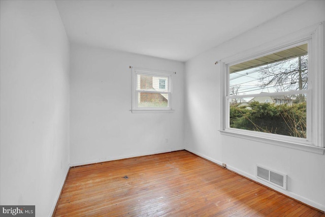 spare room with visible vents and hardwood / wood-style floors