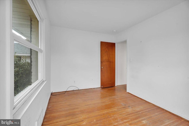 unfurnished room with visible vents, a healthy amount of sunlight, and light wood finished floors