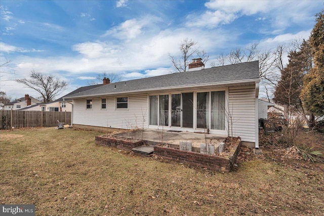 back of property with a patio, a yard, fence, and a chimney