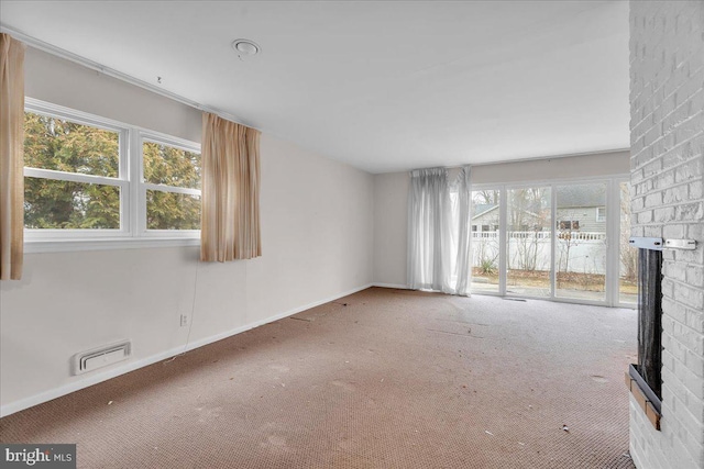 unfurnished living room featuring visible vents, baseboards, carpet, and a fireplace