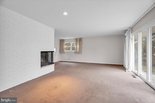 unfurnished living room featuring visible vents, brick wall, recessed lighting, a fireplace, and carpet flooring