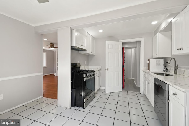 kitchen featuring a sink, light stone counters, white cabinetry, stainless steel appliances, and light tile patterned floors