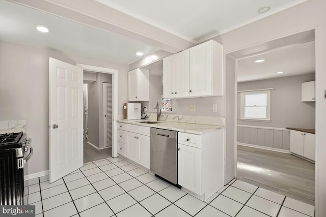 kitchen featuring light tile patterned floors, white cabinets, appliances with stainless steel finishes, and a sink