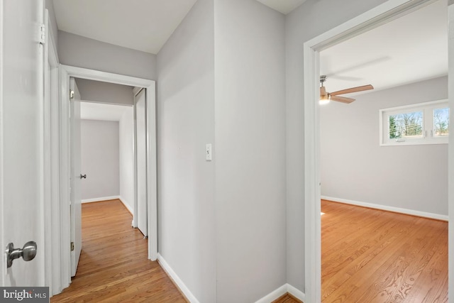 hallway with wood finished floors and baseboards