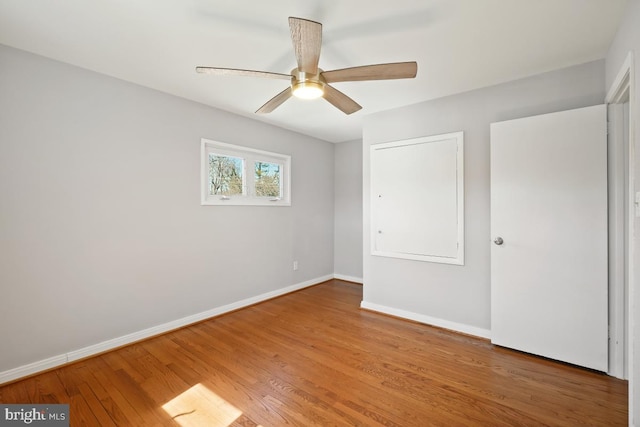 unfurnished bedroom with baseboards, wood finished floors, and a ceiling fan