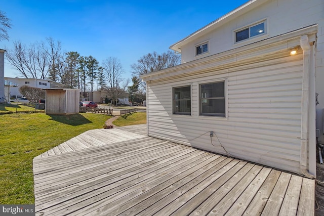 wooden terrace featuring a yard and an outbuilding