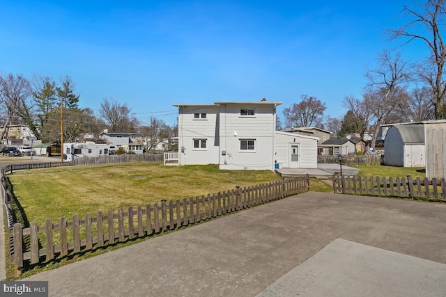 rear view of house with an outbuilding, fence, a lawn, and a residential view