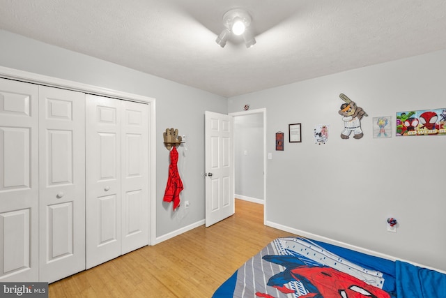 bedroom with a closet, baseboards, and light wood-style flooring