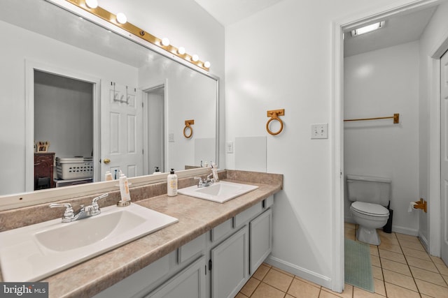 full bathroom featuring a sink, toilet, double vanity, and tile patterned floors